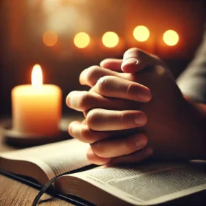 Close-up of hands clasped in prayer over an open Bible, illuminated by soft candlelight, representing personal reflection and seeking divine guidance.