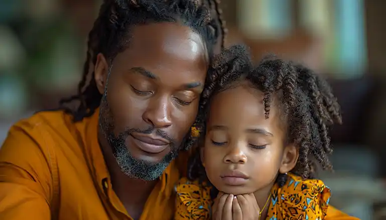 A Christian family bowing heads in prayer, integrating faith into everyday life.
