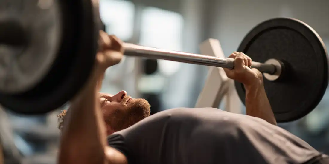 Man using a weight bench with controlled form and disciplined strength training